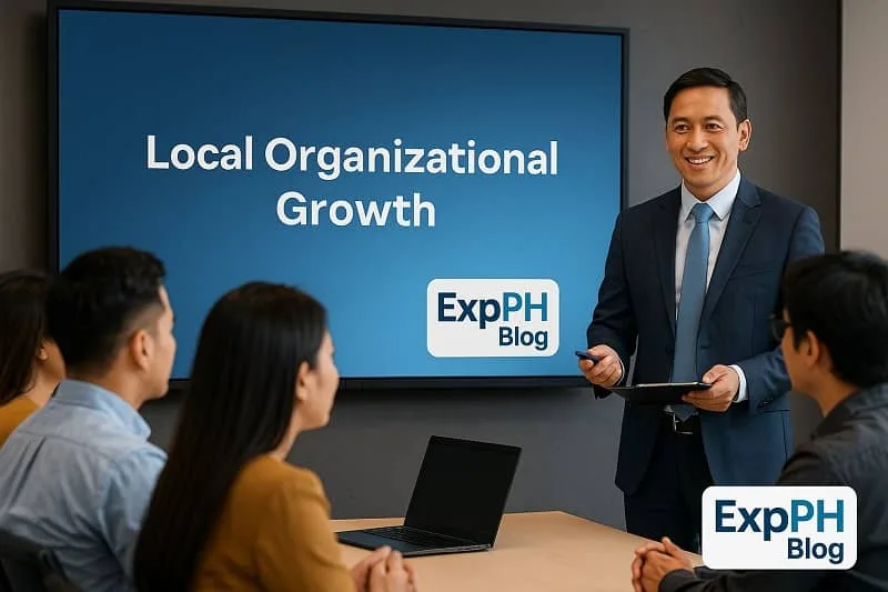 A Filipino presenter leads a meeting about local organizational growth with the ExpPH Blog logo shown on the presentation screen.
