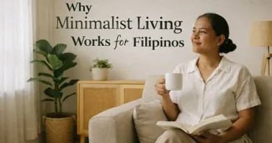Filipina woman relaxing in a minimalist living room while holding a cup of coffee and reading a book, representing calm and intentional living in a Filipino home