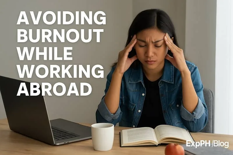 Stressed woman at desk trying to avoid burnout while working abroad with laptop and book