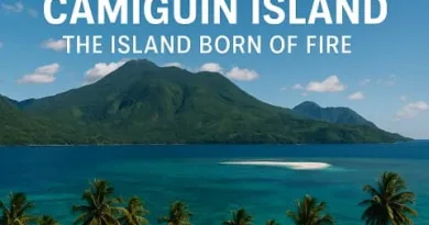 A realistic view of Camiguin Island showing Mount Hibok Hibok, turquoise waters, White Island sandbar, palm trees, and the ExpPH Blog logo.