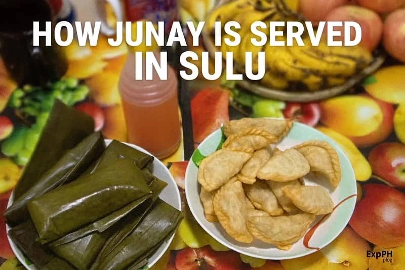 Traditional Sulu Junay wrapped in banana leaves served alongside fried pastries and a bottle of local sauce on a colorful fruit patterned table, with the ExpPH Blog logo displayed.