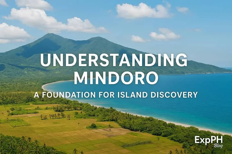 A realistic landscape view of Mindoro featuring green mountains, a curved coastline, clear blue waters, farmland scenery, and the ExpPH Blog logo, with the text Understanding Mindoro A Foundation for Island Discovery.