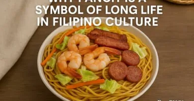 A realistic bowl of pancit with shrimp, vegetables, and meat, representing Filipino culture and the symbolism of long life, with the ExpPH Blog logo.