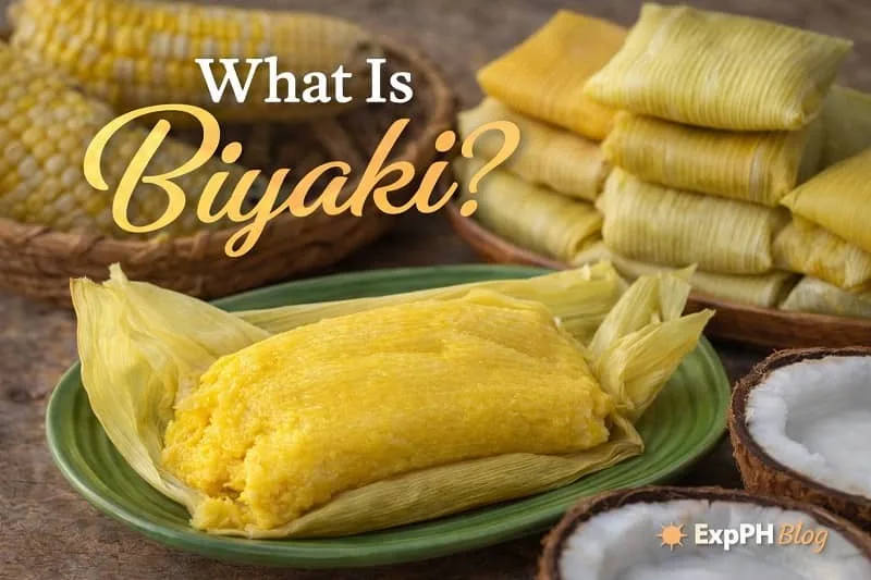 Steamed Biyaki wrapped in corn husks on a green plate with coconut and corn in the background, featuring the ExpPH Blog logo